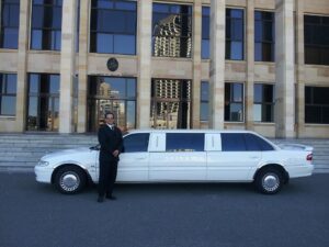 white limo and a man in black tuxedo